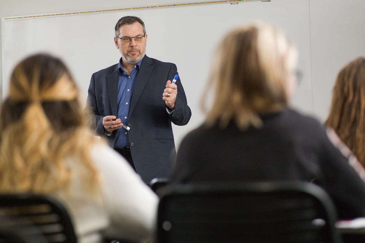 professor talking to students in a classroom